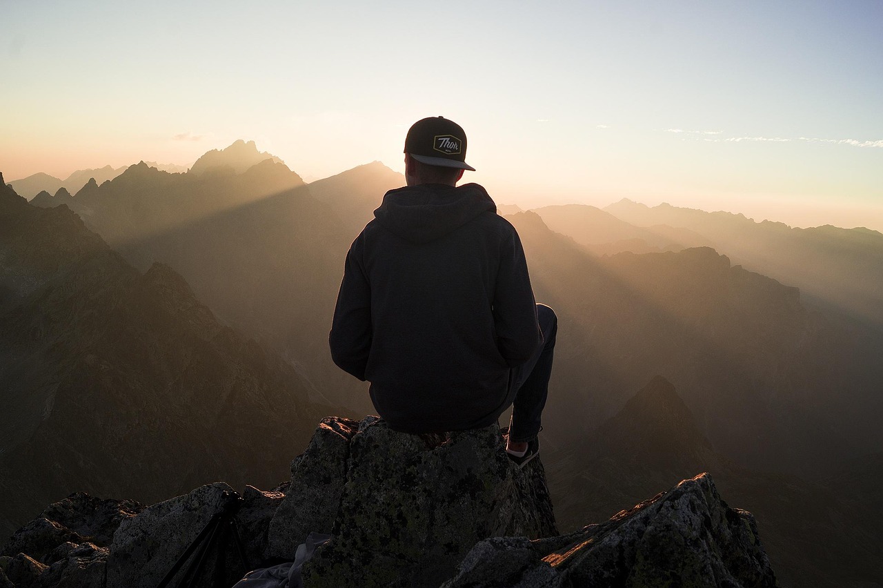 A climber checking a training plan on a phone with a mountain range in the background