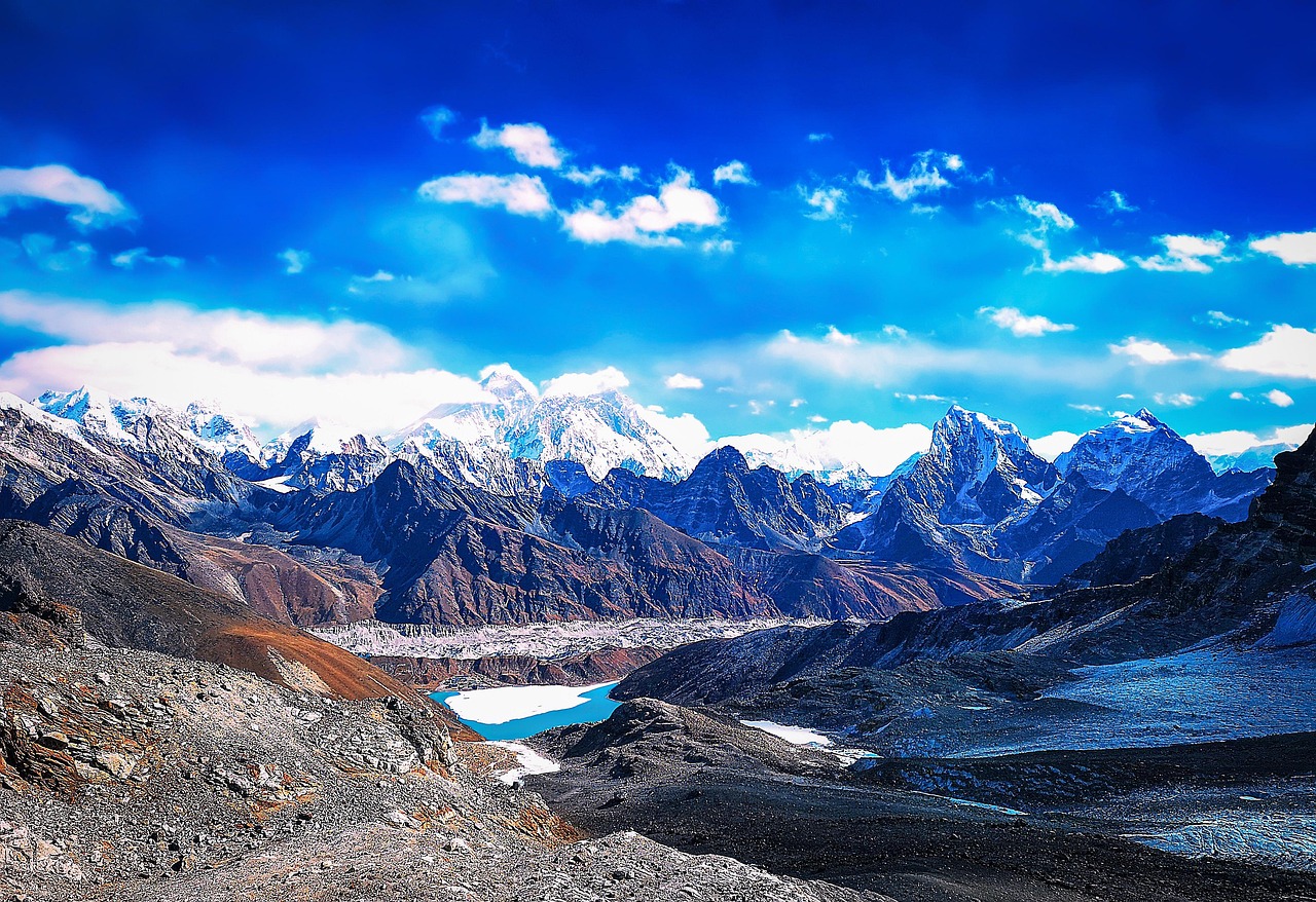 A base camp of tents beneath a snow-capped peak at dawn